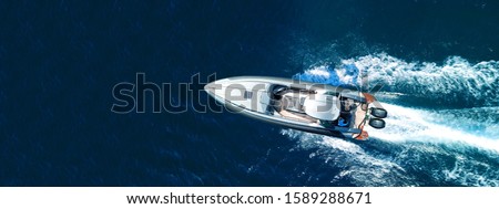 Aerial drone ultra wide top down photo of luxury rigid inflatable speed boat cruising in high speed in Aegean deep blue sea, Greece Royalty-Free Stock Photo #1589288671