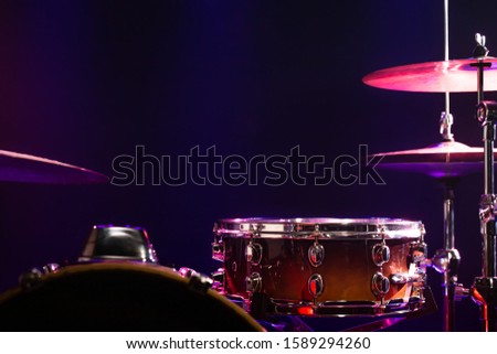 Drums and drum set. Beautiful blue and red background, with rays of light. Beautiful special effects of smoke and lighting. Musical instrument. The concept of music. Close-up photo.