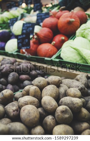 A closeup picture of vegetables in a market under lights with a blurry background