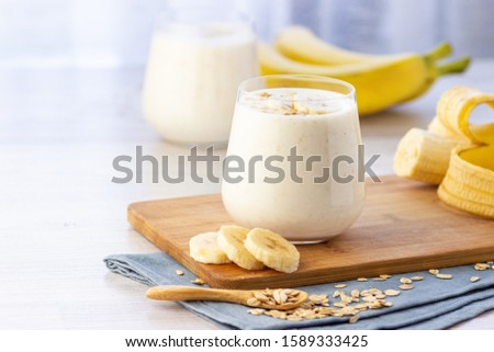 Vegan banana and oatmeal smoothie in glass jar on the light background. Healthy food. Royalty-Free Stock Photo #1589333425