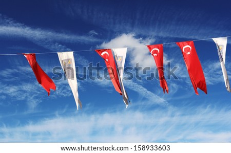 A row of Turkish flags in Kusadasi over beautiful blue cloudy sky