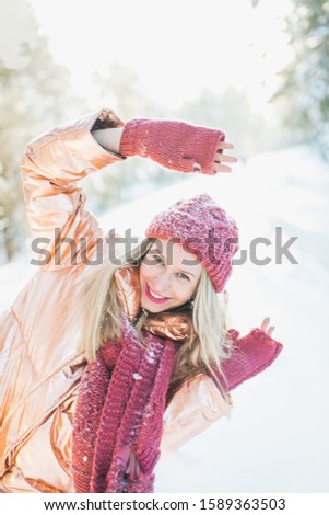 A vertical shot of a blonde female living through happy moments while enjoying the winter miracle