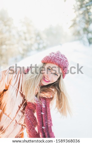 A vertical shot of a blonde female living through happy moments while enjoying the winter miracle
