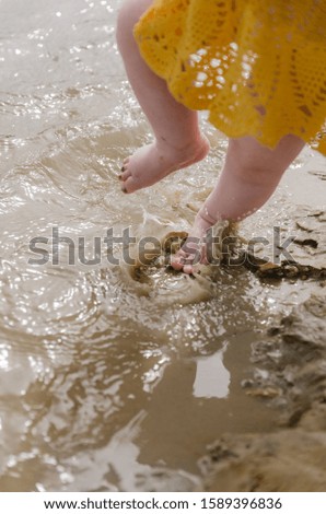 Baby girl stepping in the water for the first time