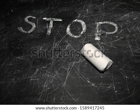 Blackboard Chalkboard with scratched texture and word stop, white chalk.Empty black chalkboard.School board background with traces of chalk.