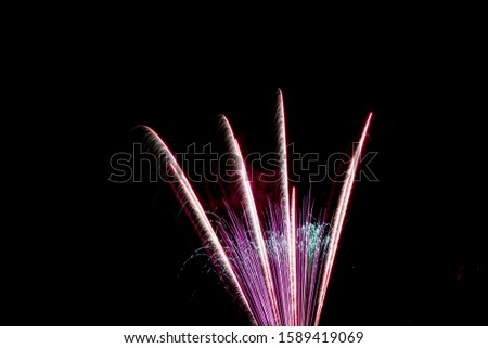 Bright colourful fireworks bursts against a dark night sky with text space  Royalty-Free Stock Photo #1589419069