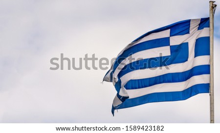 Greek national flag waving on blue sky background. Hellenic Republic, GR