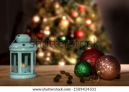 Holiday Christmas decoration. Festive decoration with lantern, pine cones, Christmas tree and ornaments on a wooden table