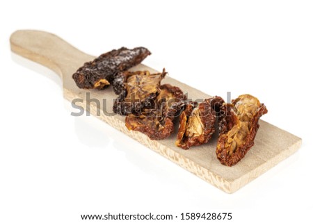 Lot of whole dried red tomato piece on wooden cutting board isolated on white background