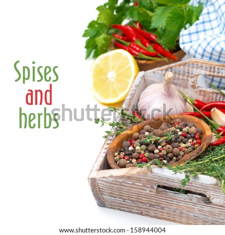 spices and fresh herbs on a wooden tray, isolated on white, close-up