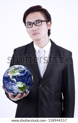Confident asian businessman holding the planet earth isolated over white background. Earth image courtesy NASA