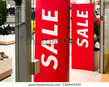 The entrance to the retail store of clothes and shoes with a red inscription sale.