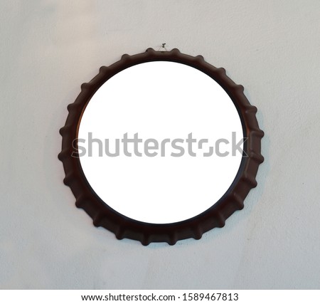 picture frame of bottle cap shape on concrete wall at cafe.