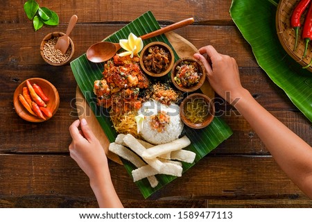 Chicken Geprek with typical Balinese flavor.  Served with warm rice, serundeng, various sambal such as sambal matah and rambak crackers. Royalty-Free Stock Photo #1589477113
