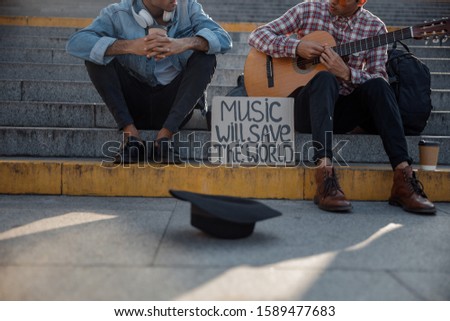 Cropped photo of black hat for money with musicians in the background stock photo