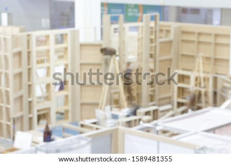 Blurred image of the installation of wood and plywood structures for the event.