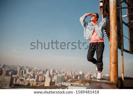 Happy lady standing on rooftop during sunny day stock photo