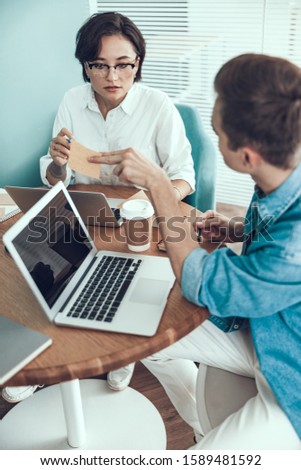 Young man showing sticker to his female colleague stock photo