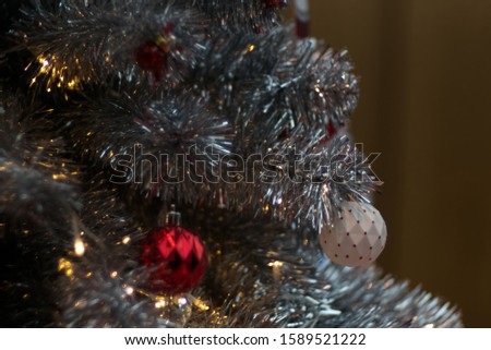 A red dotted white ball on a glitter silhver mistletoe
