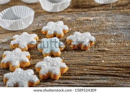 Iced, Santa and snowflake decorated Christmas cookies on rustic wood surface with dramatic lighting