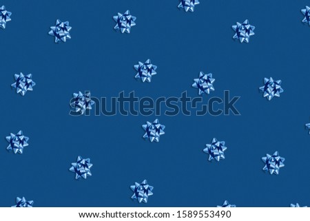 Christmas and new year pattern. Celebration picture. Classic blue background with blue bright ribbon bows. Flat lay, top view.