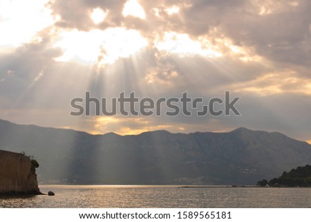 Sunbeams through the clouds above the sea. Dramatic sky