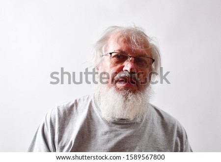 Old Caucasian male making faces at the picture of is ex wife.

  Is happy to be self isolating from all the salesmen, ex wife and stupid people.