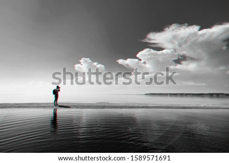 traveler photographer with backpack taking pictures of the sea at rest under the blue beautiful sky. Black and white photo with 3D glitch effect