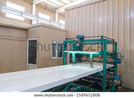 Press machine glutes panel. Plant for the production of sandwich panels from styrofoam Royalty-Free Stock Photo #1589652808