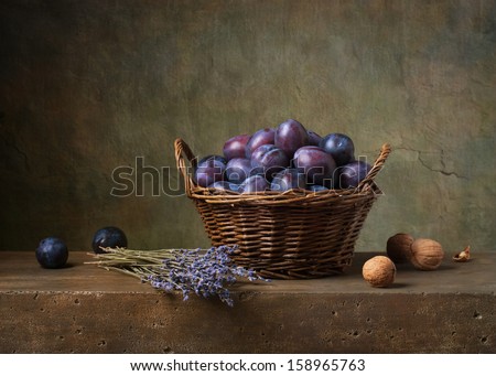 Still life with plums in a basket on the table