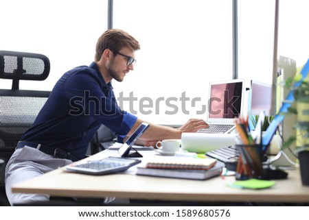 Elegant modern businessman analyzing data while working in office