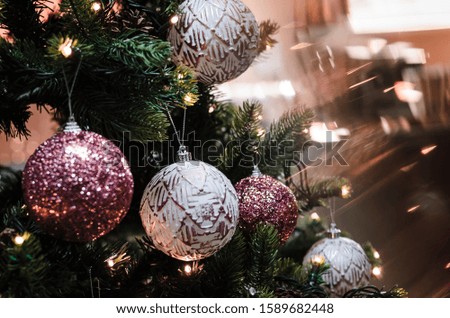 Christmas ornaments, red, white and silver balls on christmas tree with cosy, warm lights