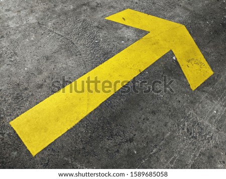 Yellow arrow sign on asphalt texture..arrow showing forward direction