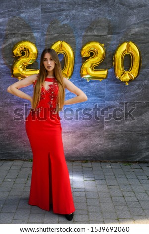Studio portrait of beautiful women with golden numbers air balloons . Happy New Year 2020 holiday party concept
