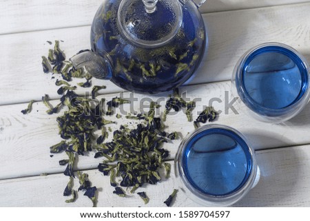 Organic blue tea Anchan, Clitoria, Butterfly tea in a glass teapot with two cup. White wood table background. Top view.