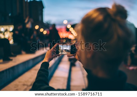 Back view of female generation photographing city urban setting during journey getaway connected to 4g wireless for sharing pictures to social media website, millennial woman taking images via camera