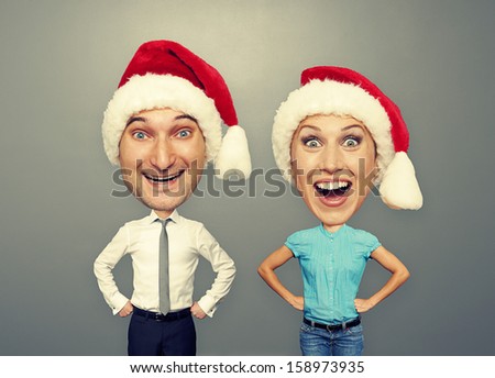 excited couple in santa hat over grey background