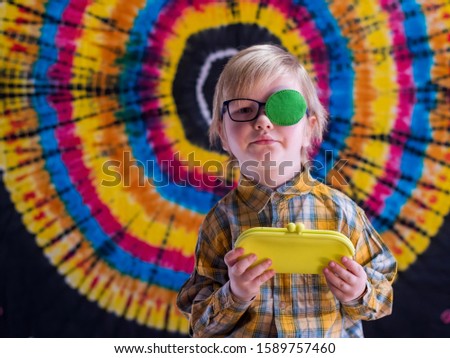Portrait of funny child in new glasses with green spot to correct strabismus and yellow eyeglass case
Orthopedic Boys Eye Patches eyewear for strabismus (lazy eye)