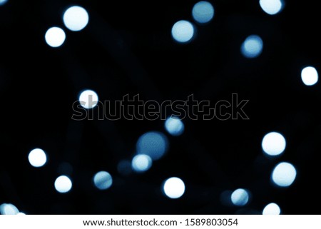 Abstract background with classic blue glitter light bokeh isolated on black background. Concept of color of the year 2020. It can be used as overlay design.