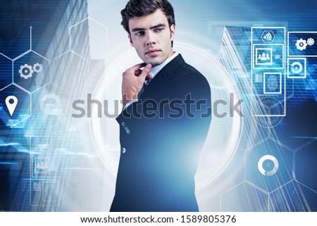 Pensive young businessman standing in city with double exposure of immersive blurry cloud computer HUD interface. Concept of hi tech startup. Toned image