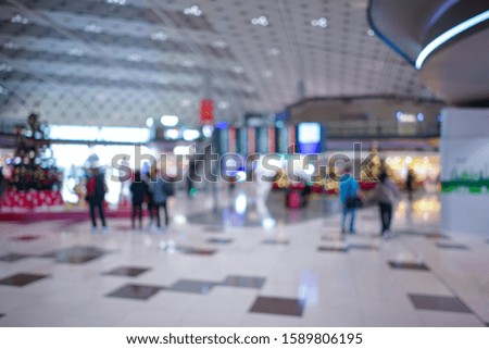 Airport terminal blurred crowd of Travelling people with bokeh light on the Background. Traveling concept.