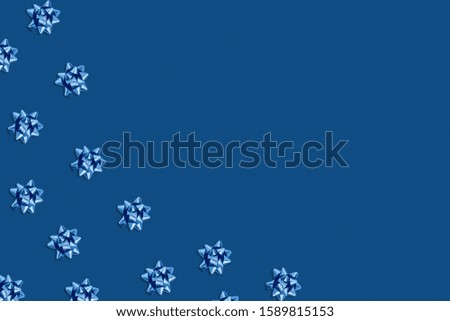 Christmas and new year pattern. Celebration picture. Classic blue background with blue bright bows. Flat lay, top view, copy space.