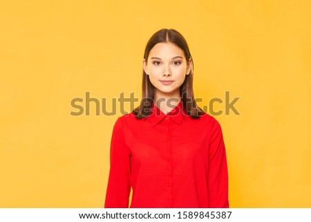 Beautiful woman in a red shirt on a yellow background model girl