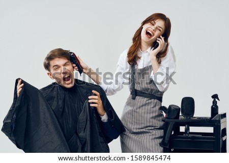 A woman talking on the phone and doing hairstyle man negligence emotions                      Royalty-Free Stock Photo #1589845474