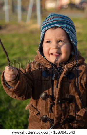 Sweet little boy on the street. Boy with a stick