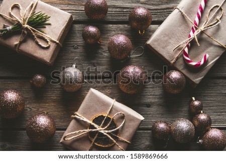 Christmas background with fir tree, present box and decorations on wooden background. Top view