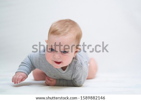 emotional portrait of a child. photo on a neutral background in gray clothes
                        