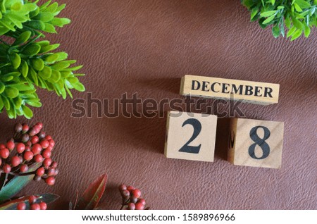 December 28. Number cube in natural concept on leather for the background