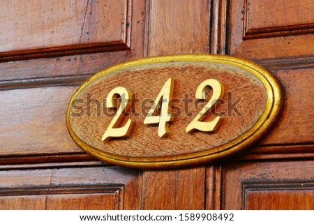 Oval plate on door with number two hundred and forty-two. 
