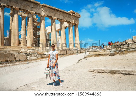 Ancient temple Parthenon in Acropolis Athens Greece and portrait of young woman on a bright blue sky background. The best travel destinations.